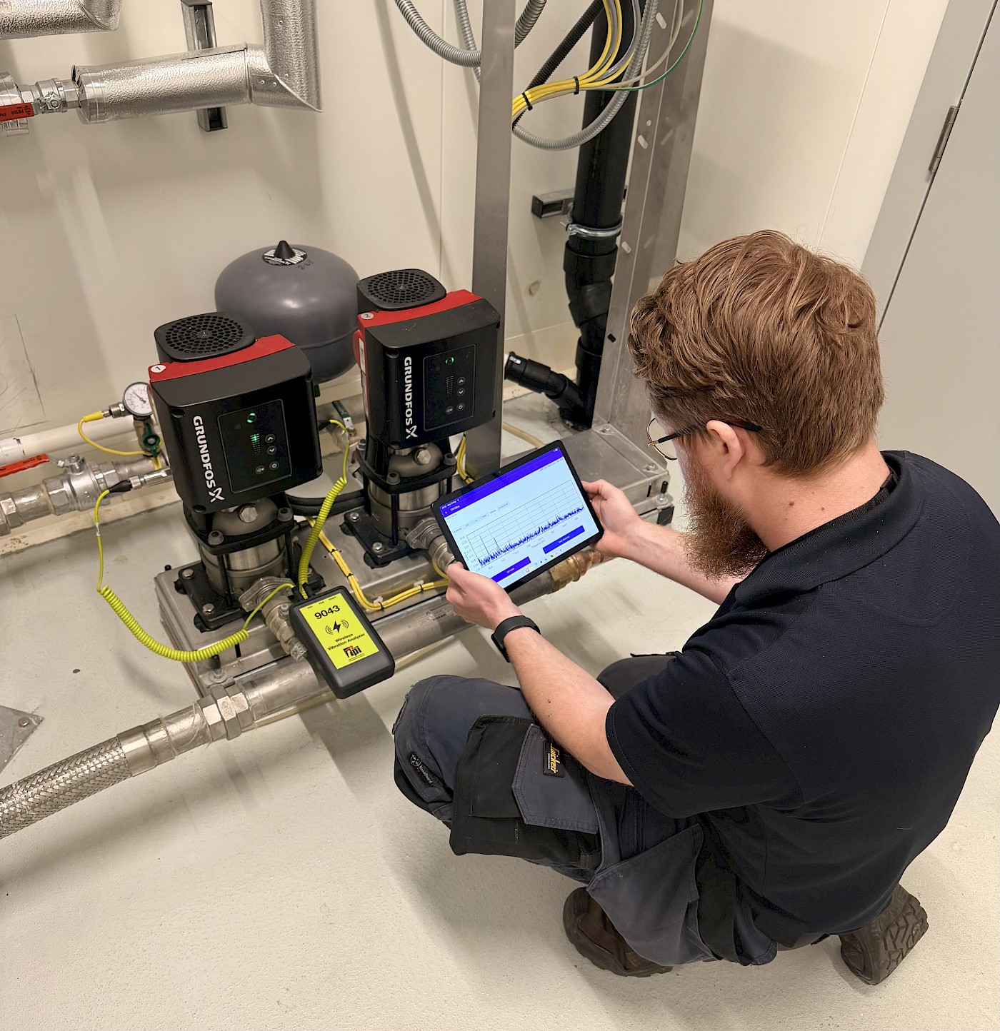 Engineer testing vibration analysis on pump